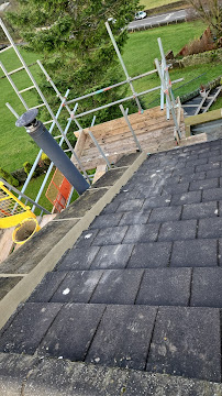 Close-up of a Bradford slate roof under repair: loose slate being refixed and fresh lead flashing dressed into mortar by Leafield Roofing