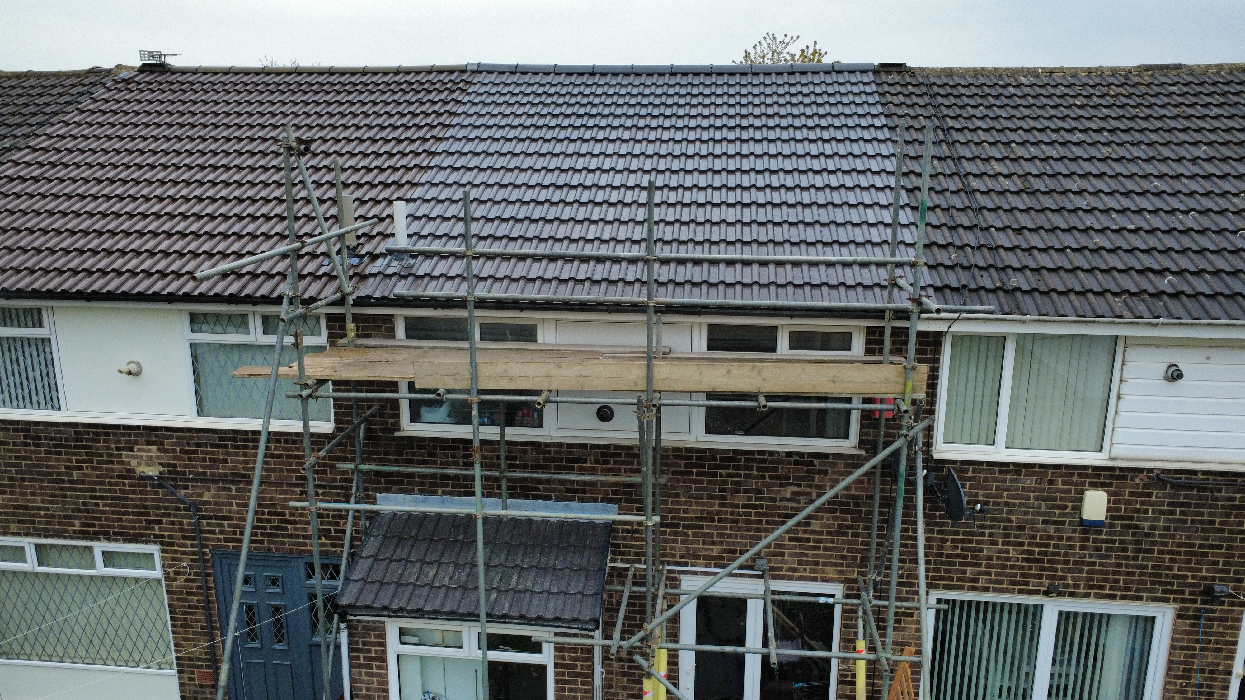 Leafield Roofing repairing a Bradford terraced house roof — scaffolding erected, team at work
